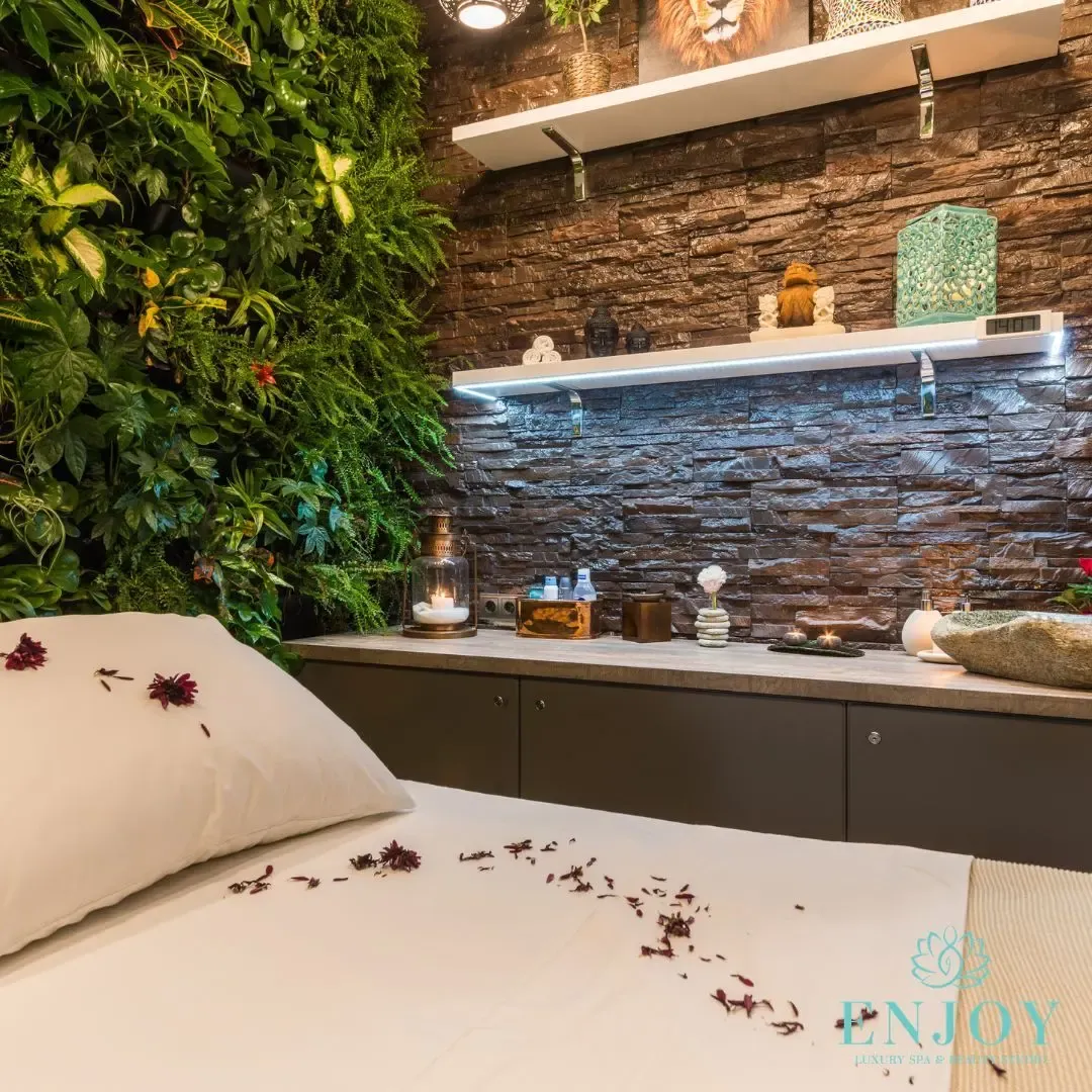 Stone interior of a massage room with rose petals — Enjoy Spa